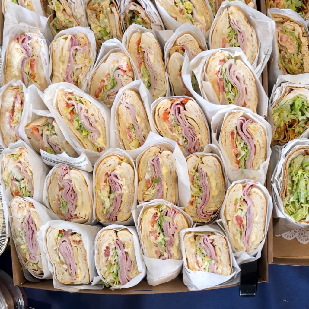 Tray of halved turkey, ham, and veggie deli wraps