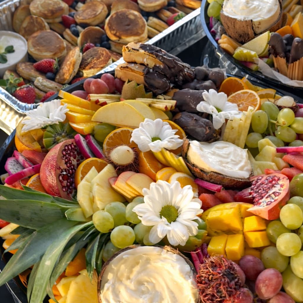 Fruit and charcuterie platter with mini pancakes, brie, fresh strawberries, grapes